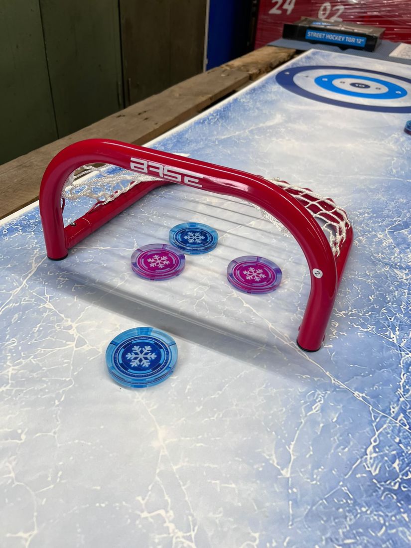 Neue Pucks mit Schneeflocken-Motiv vor einem kleinen Tor
